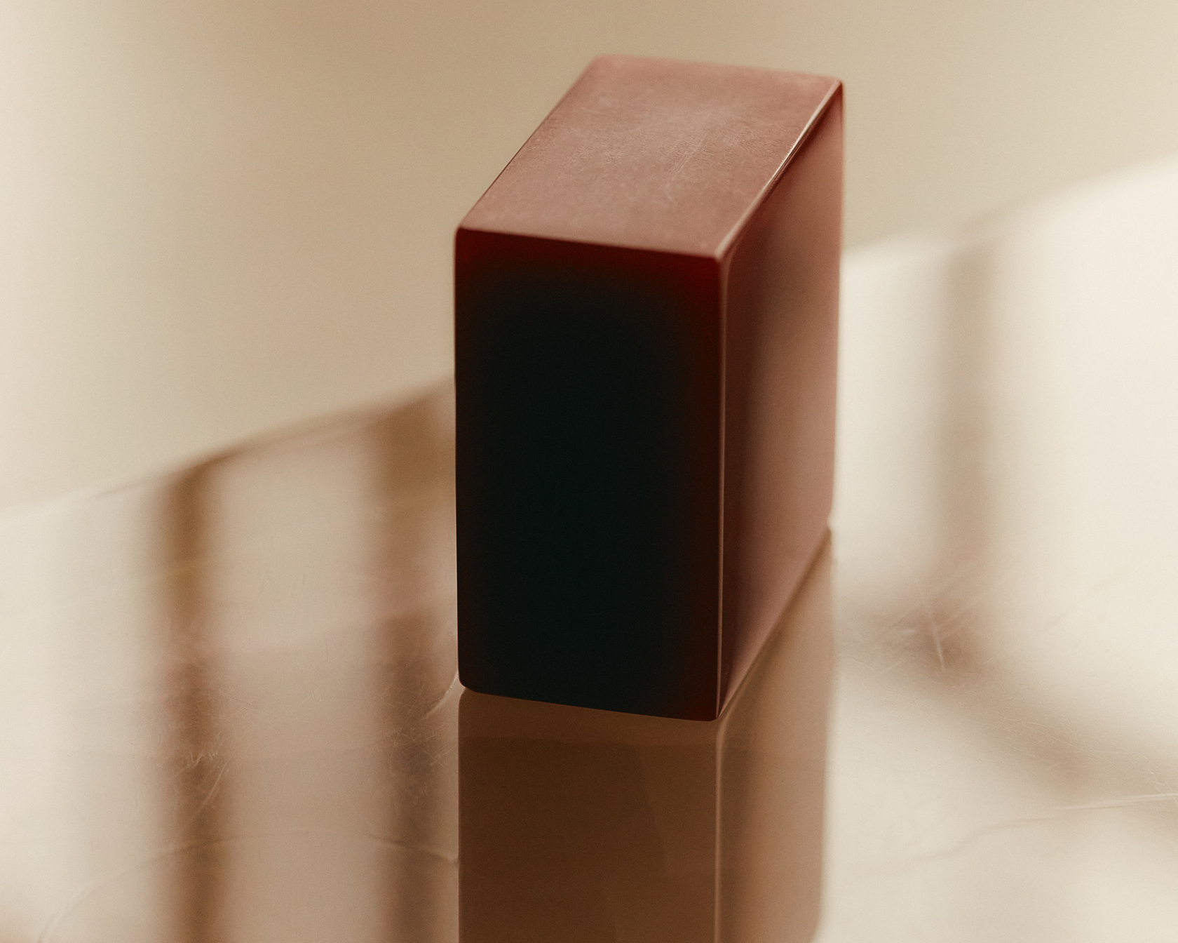 Minimalist design of a red block with reflection on a glossy surface