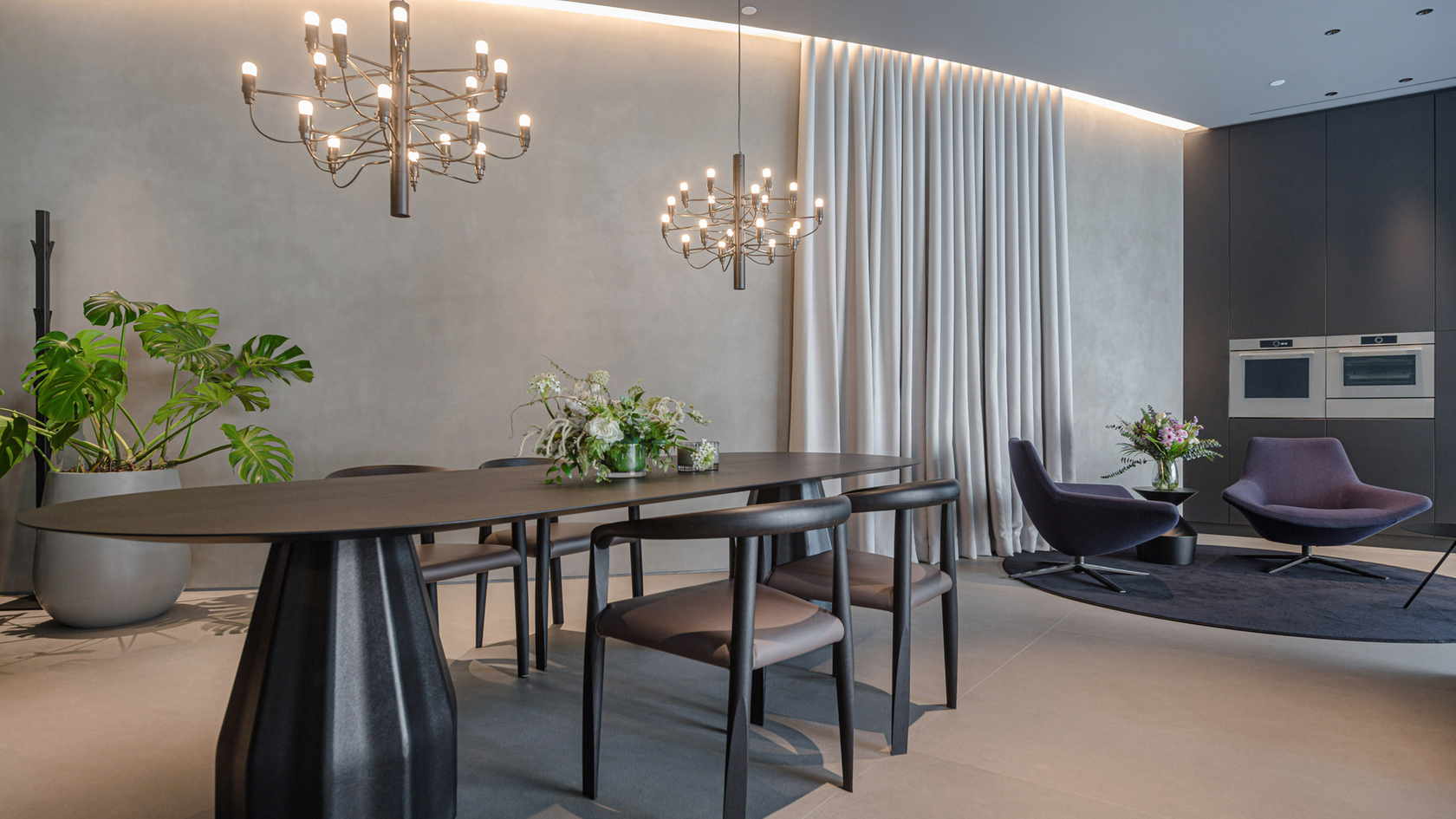 Modern kitchen with dining table, designer chairs and integrated ovens