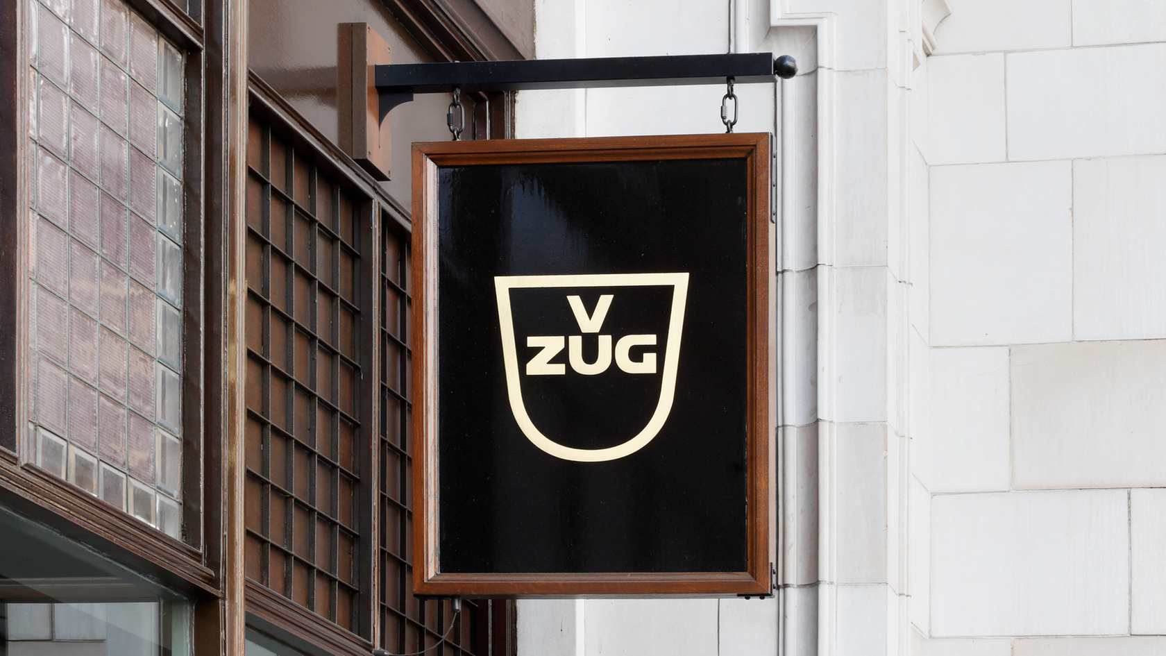 Logo V-ZUG su un'insegna nera sulla facciata di un edificio storico
