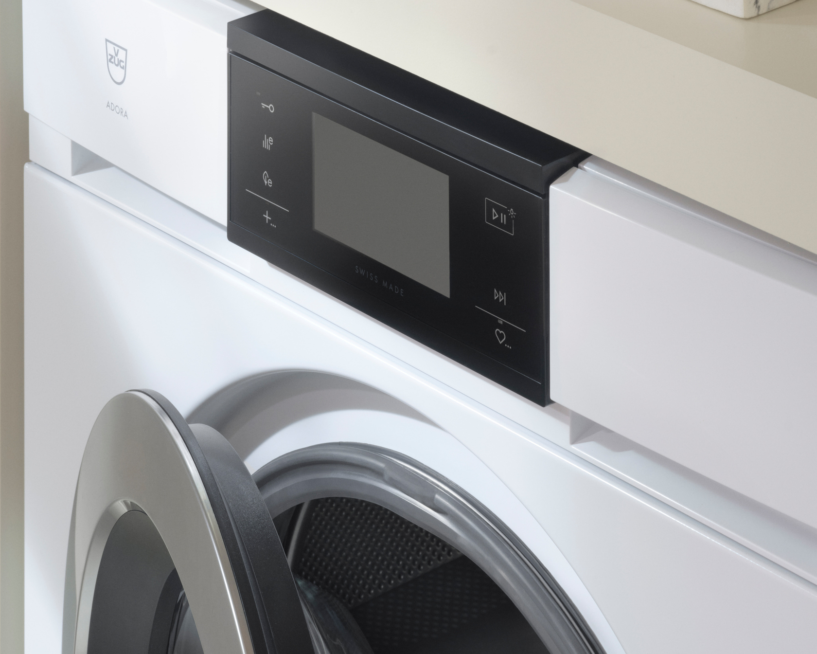 Modern washing machine with open drum and elegant user interface under a worktop.