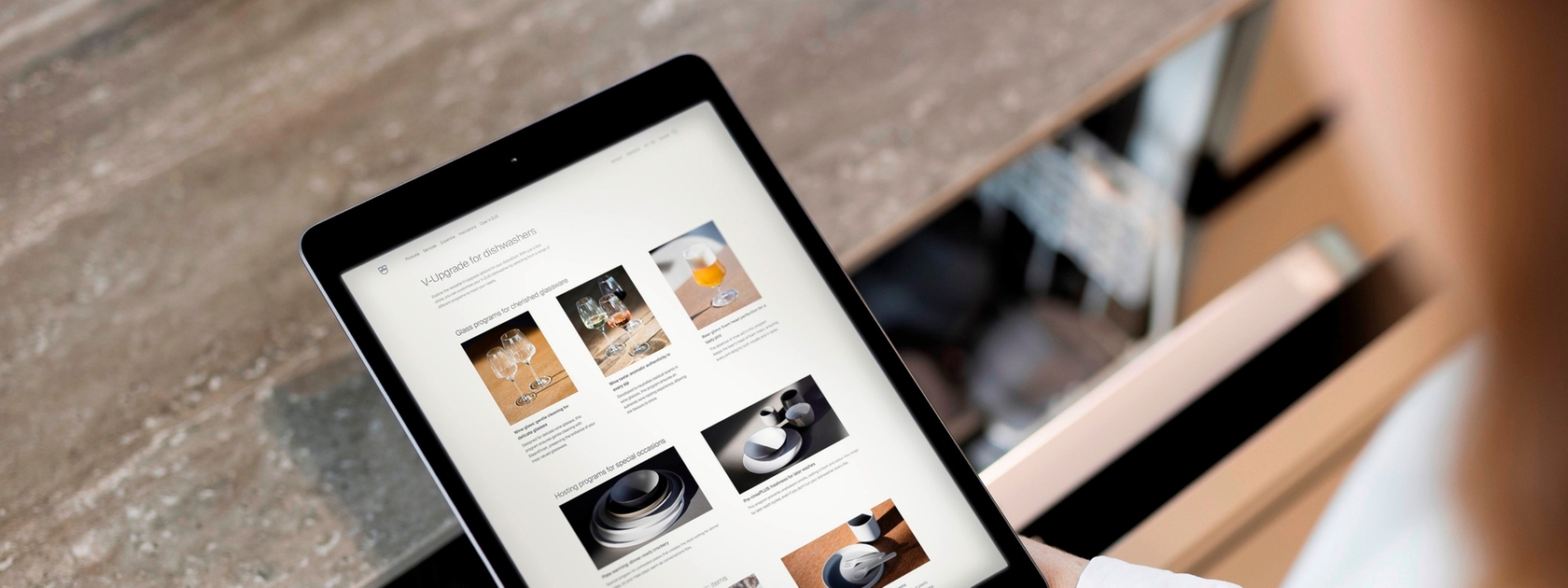 Tablet in moderner Küche mit Geschirrspüler im Hintergrund