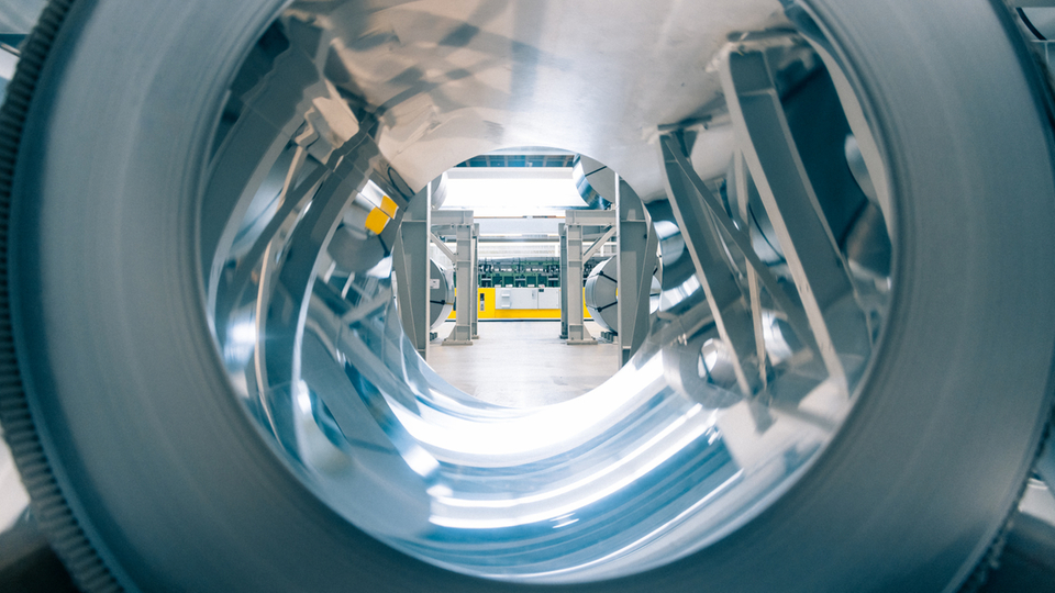 Stainless steel roll in a production hall representing industrial manufacturing and modern technology.