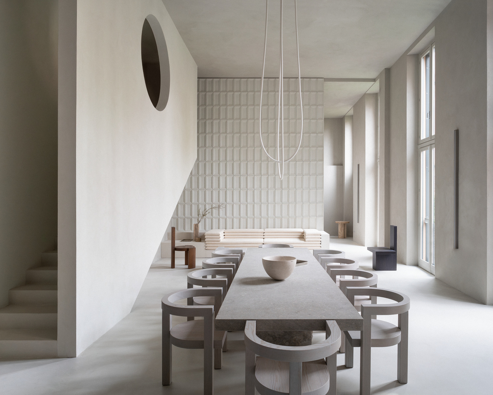 Sala da pranzo minimalista con grande tavolo e luce naturale
