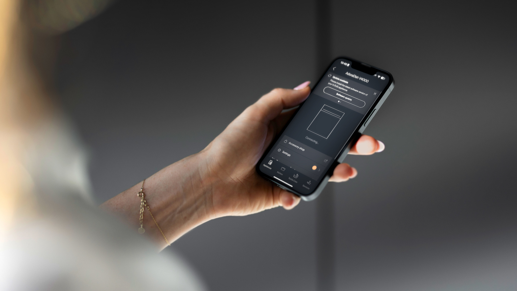 Hand with smartphone and open V-ZUG app to control household appliances