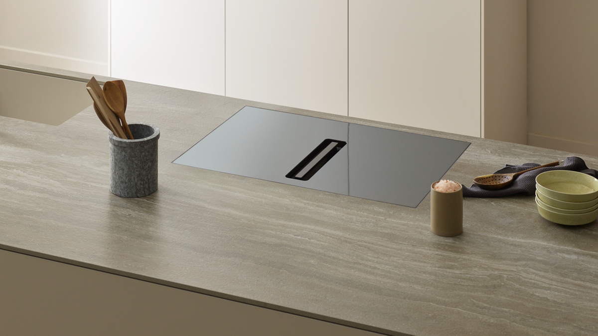 Piano cottura moderno con aspiratore integrato in una cucina elegante