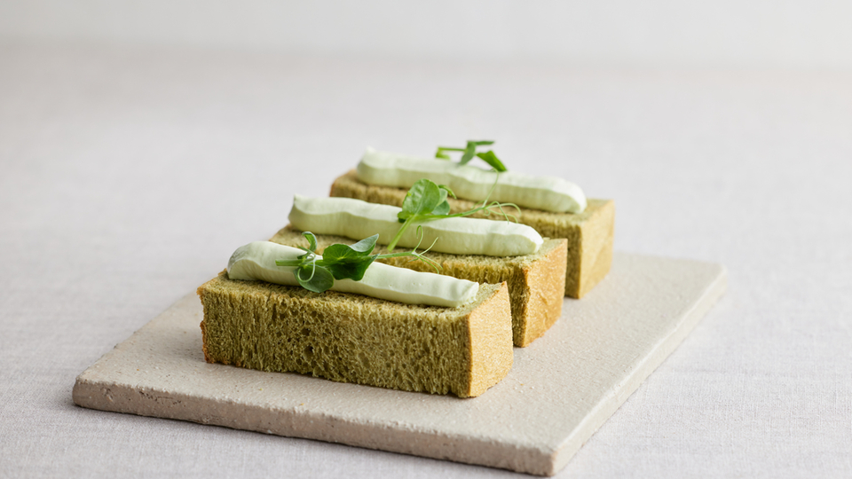 Matcha sandwich with cream and herbs on a stone plate
