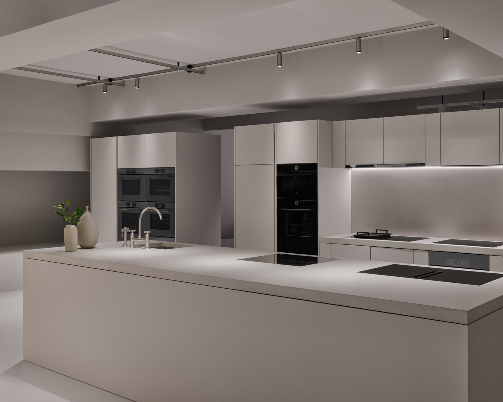 Modern kitchen with cooking island, built-in ovens and minimalist design.