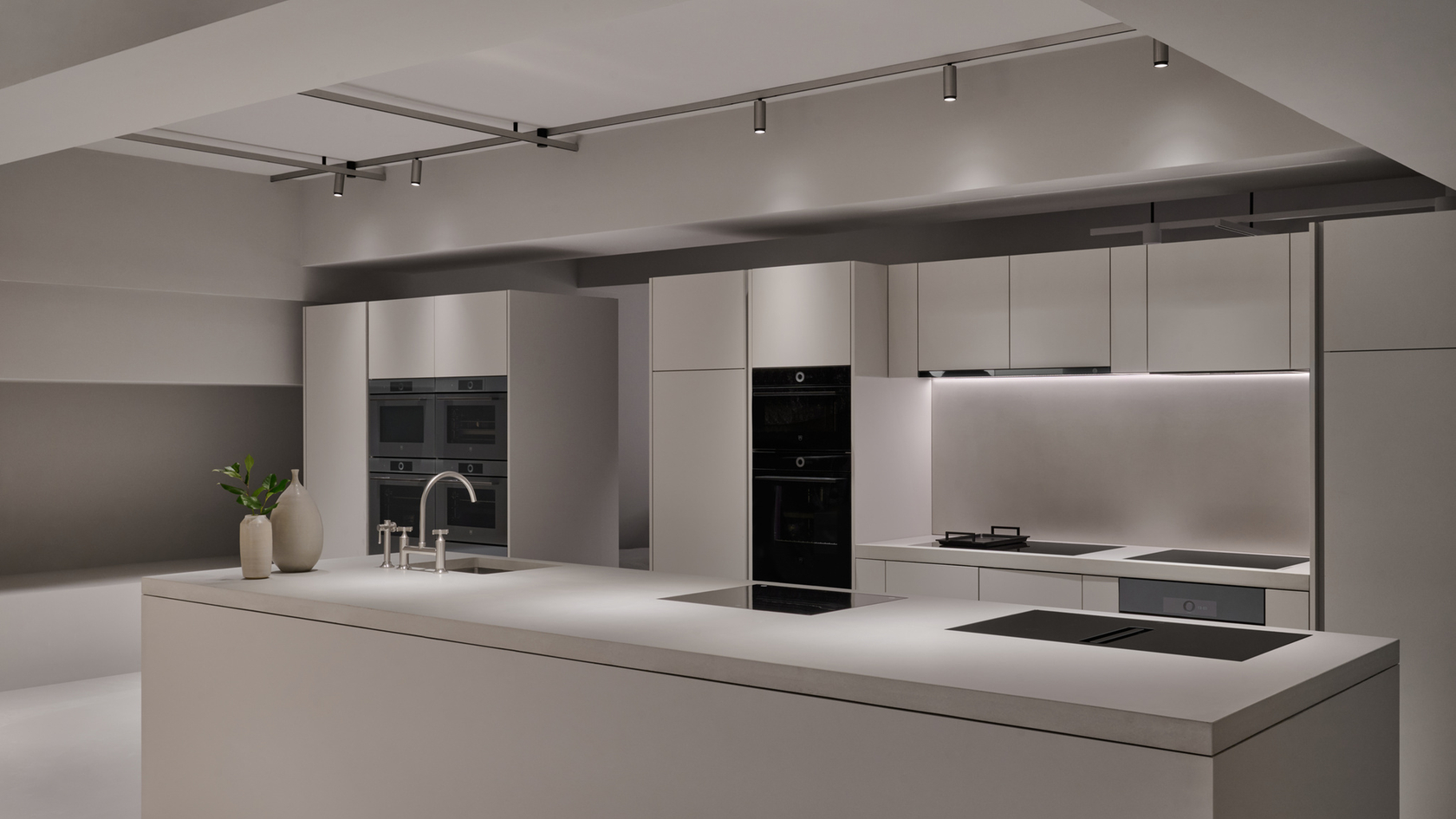 Modern kitchen with cooking island, built-in ovens and minimalist design.