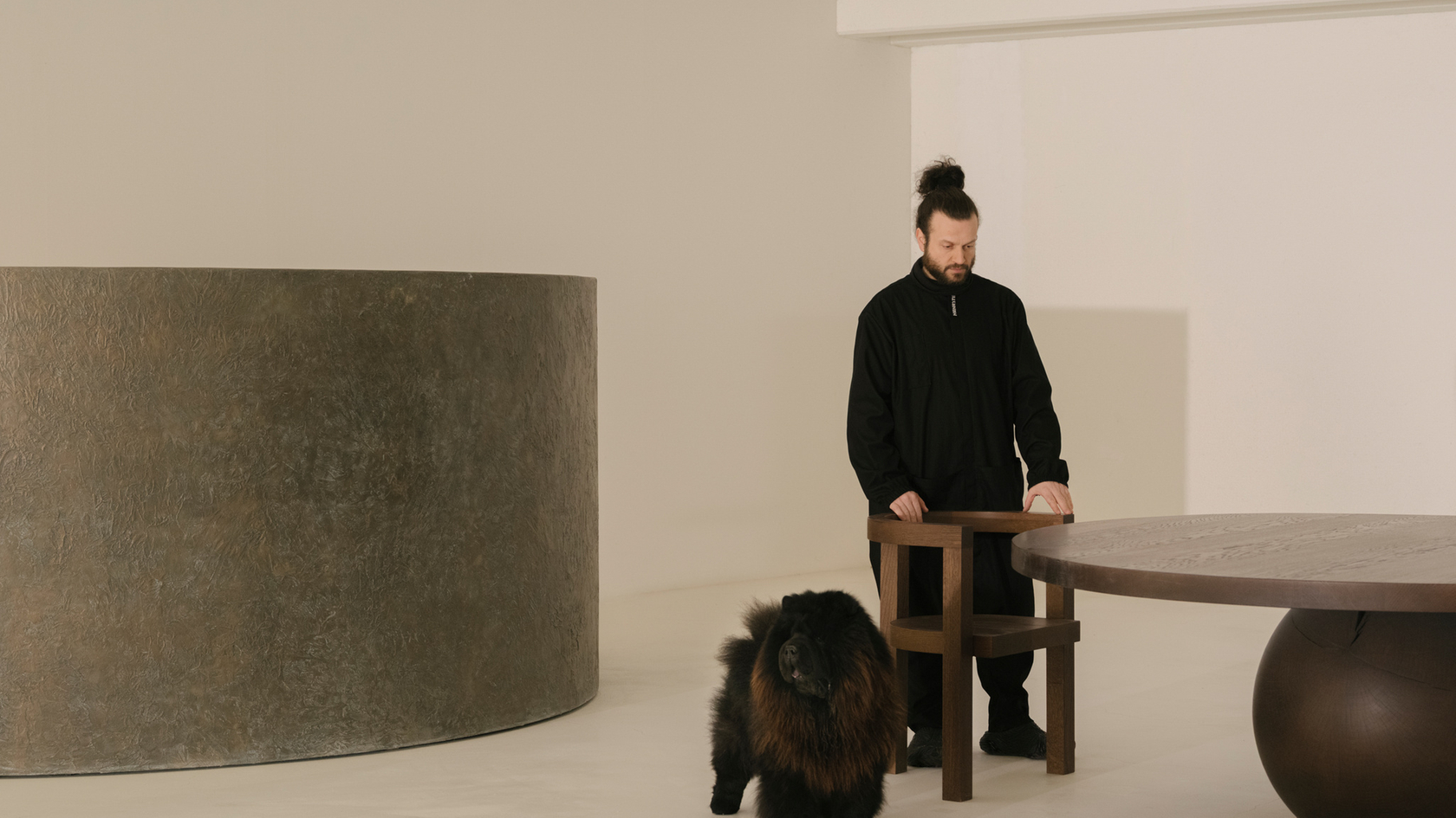 Zwarte hond in een minimalistische kamer met modern design en meubels.