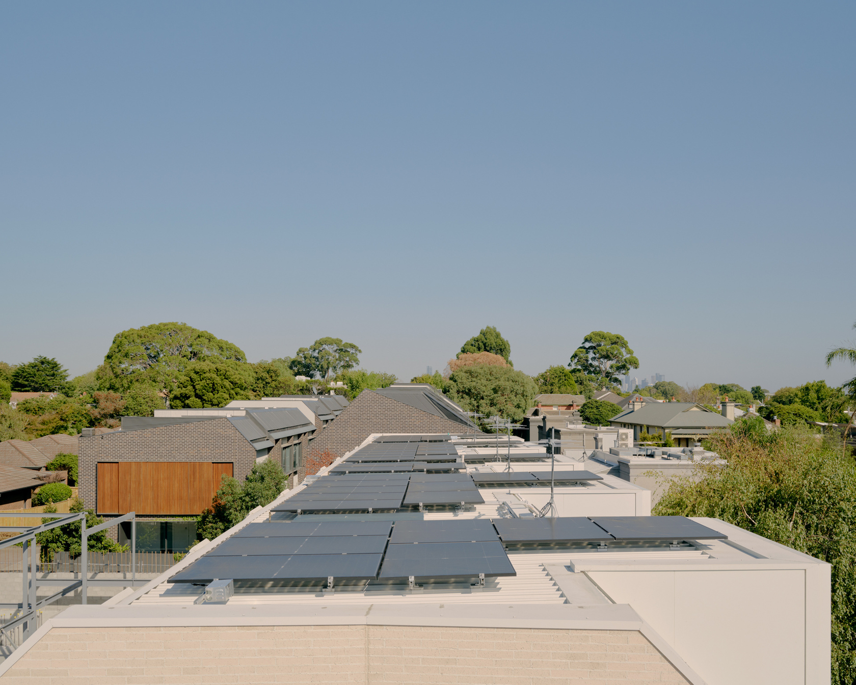 Solar panels on the roofs of modern houses in a green residential area