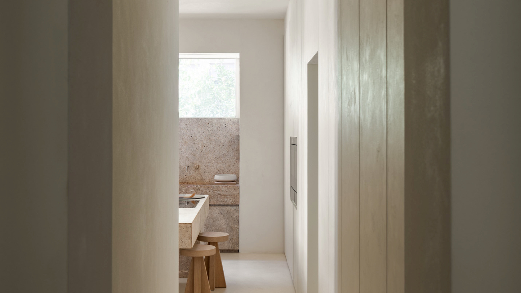 Cuisine minimaliste avec lumière naturelle, éléments en bois chaleureux et appareils modernes.