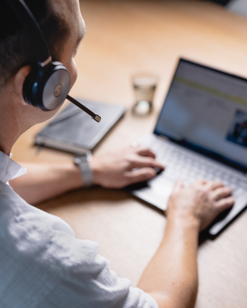 Supporto al dipendente con cuffie che lavora su un laptop