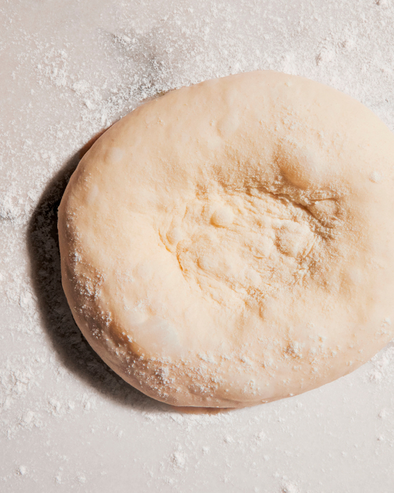Fresh dough on a floured work surface in the kitchen
