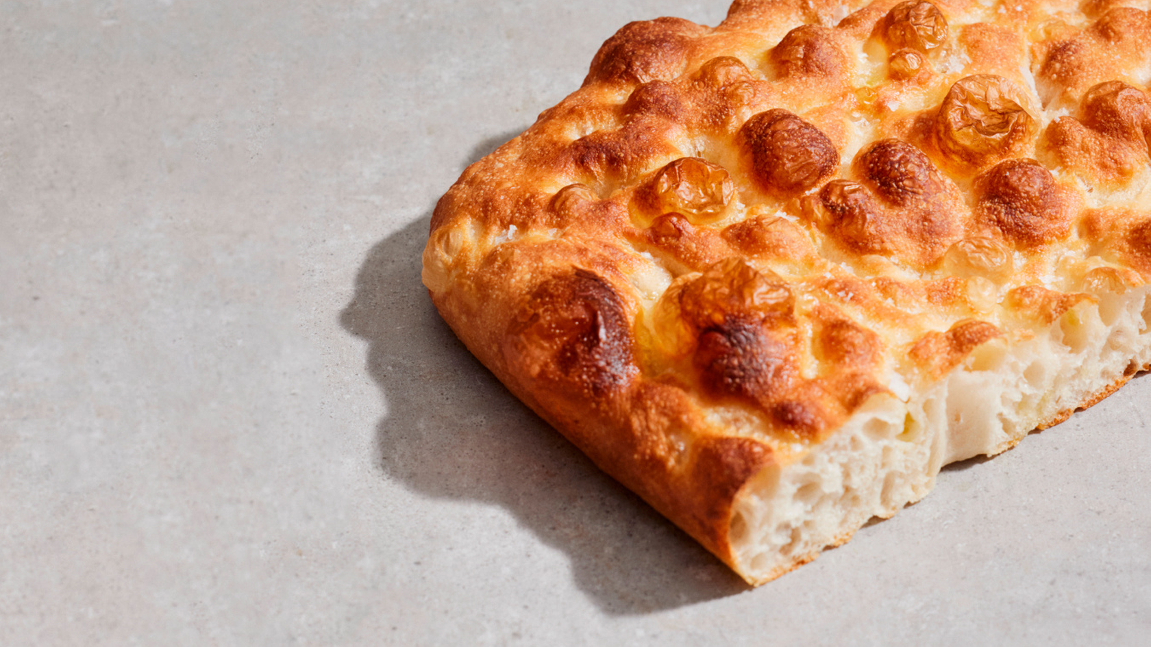 Close-up of a freshly baked focaccia with a crispy crust and soft texture.
