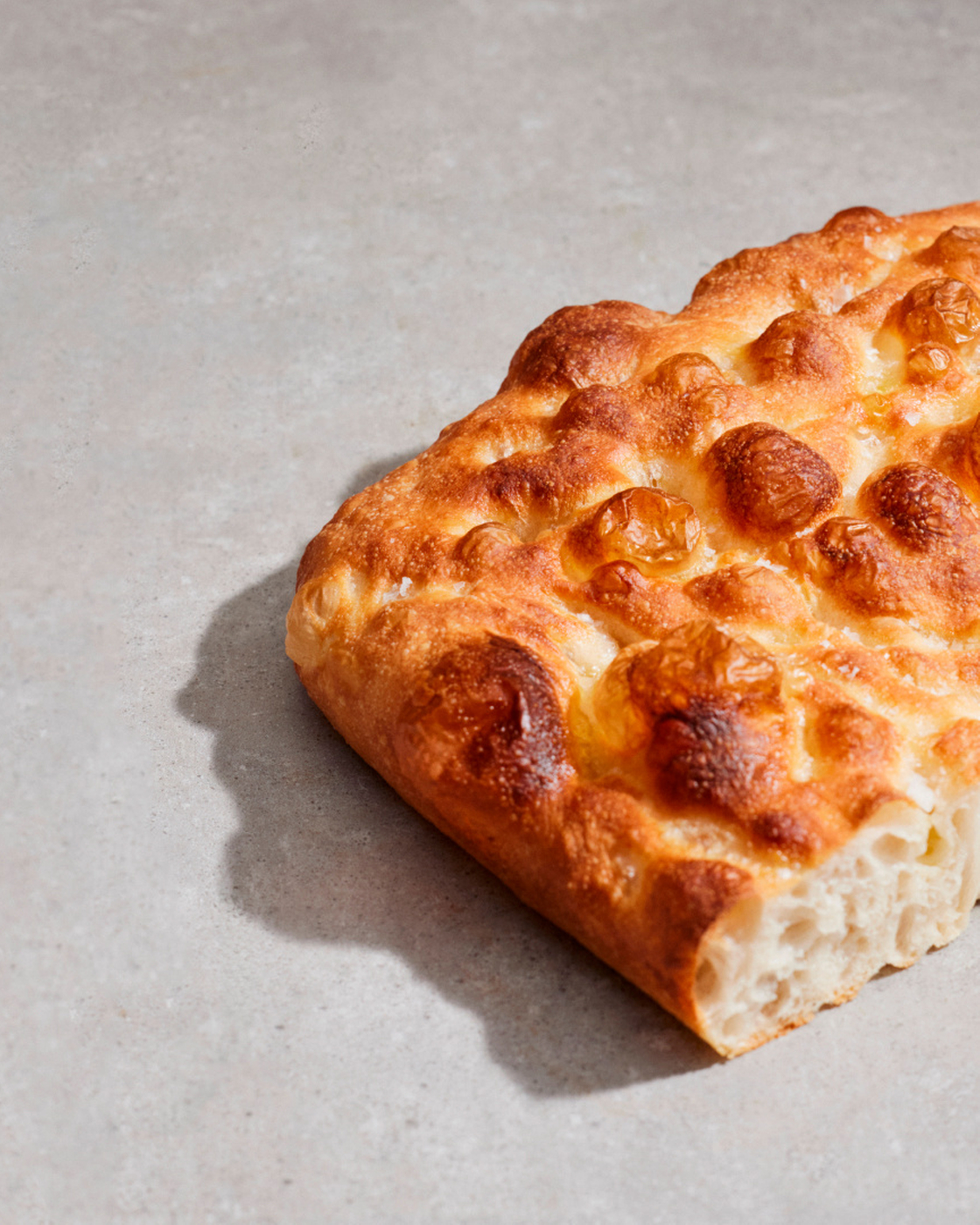 Close-up of a freshly baked focaccia with a crispy crust and soft texture.