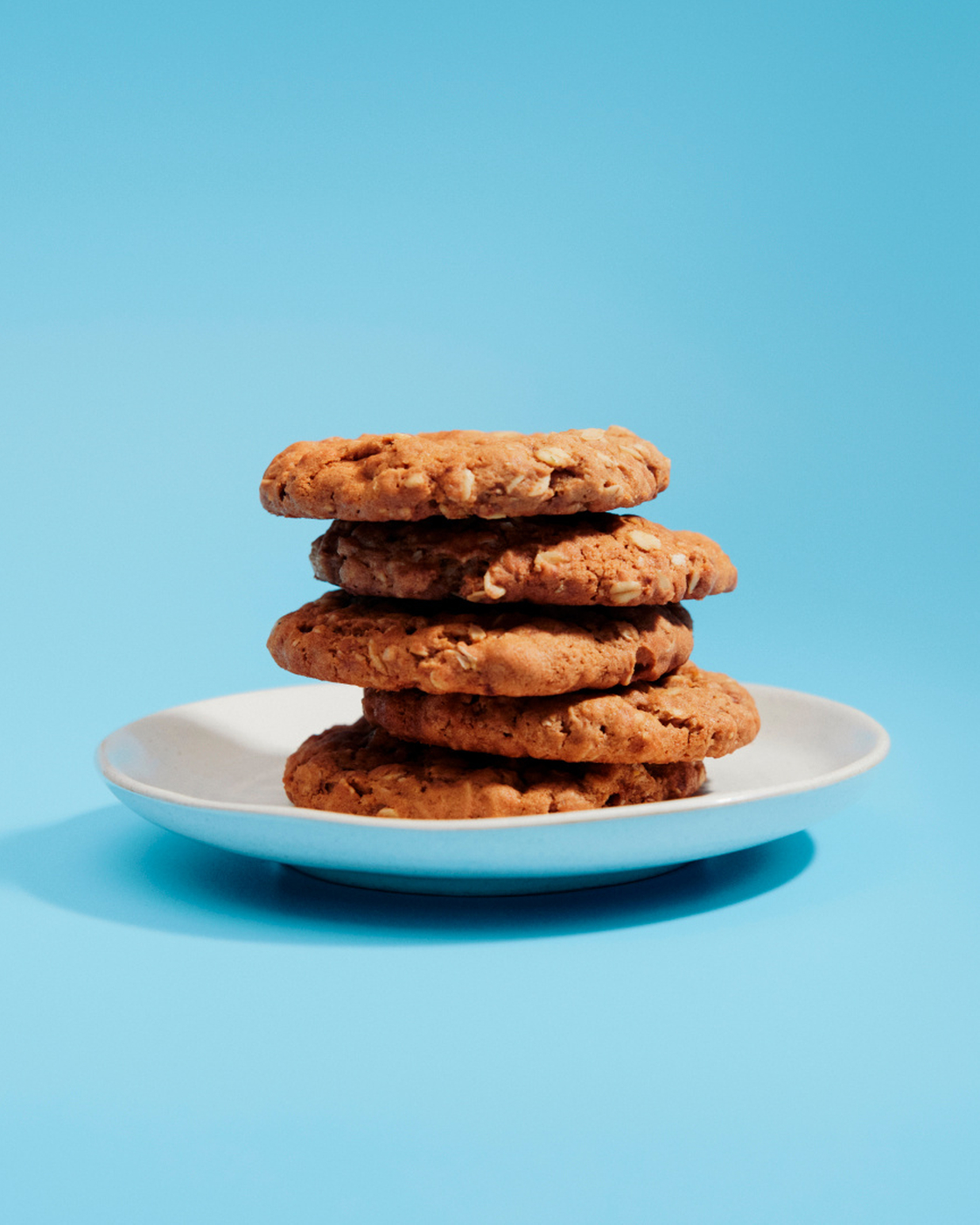 Freshly baked cookies on a plate against a blue background