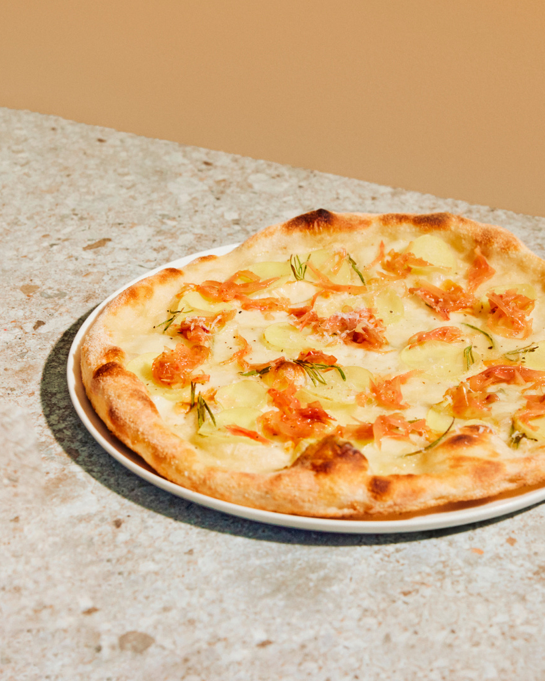 Freshly baked pizza with potatoes and rosemary on a plate