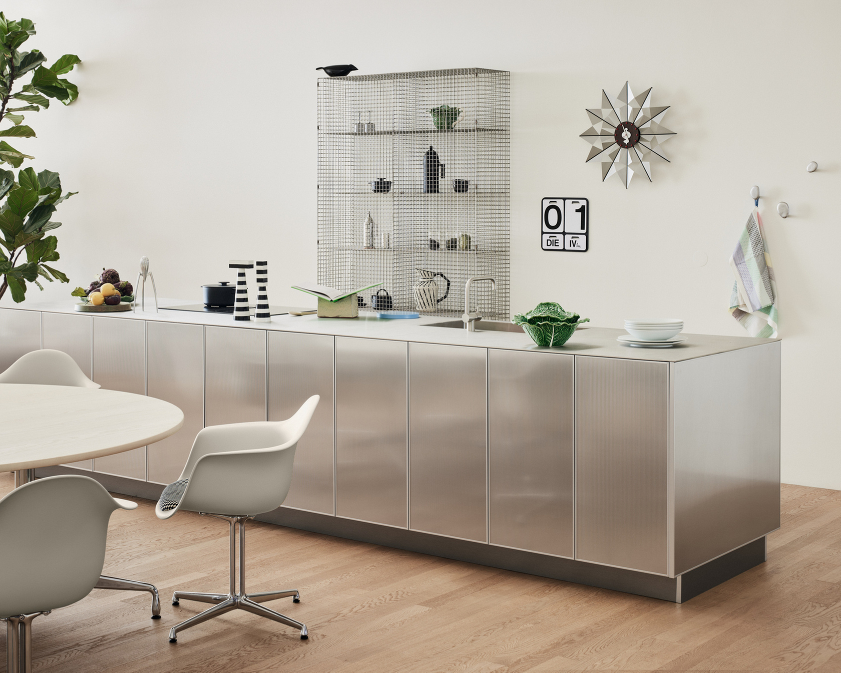 Modern kitchen with stainless steel island, minimalist furniture and decorative elements.