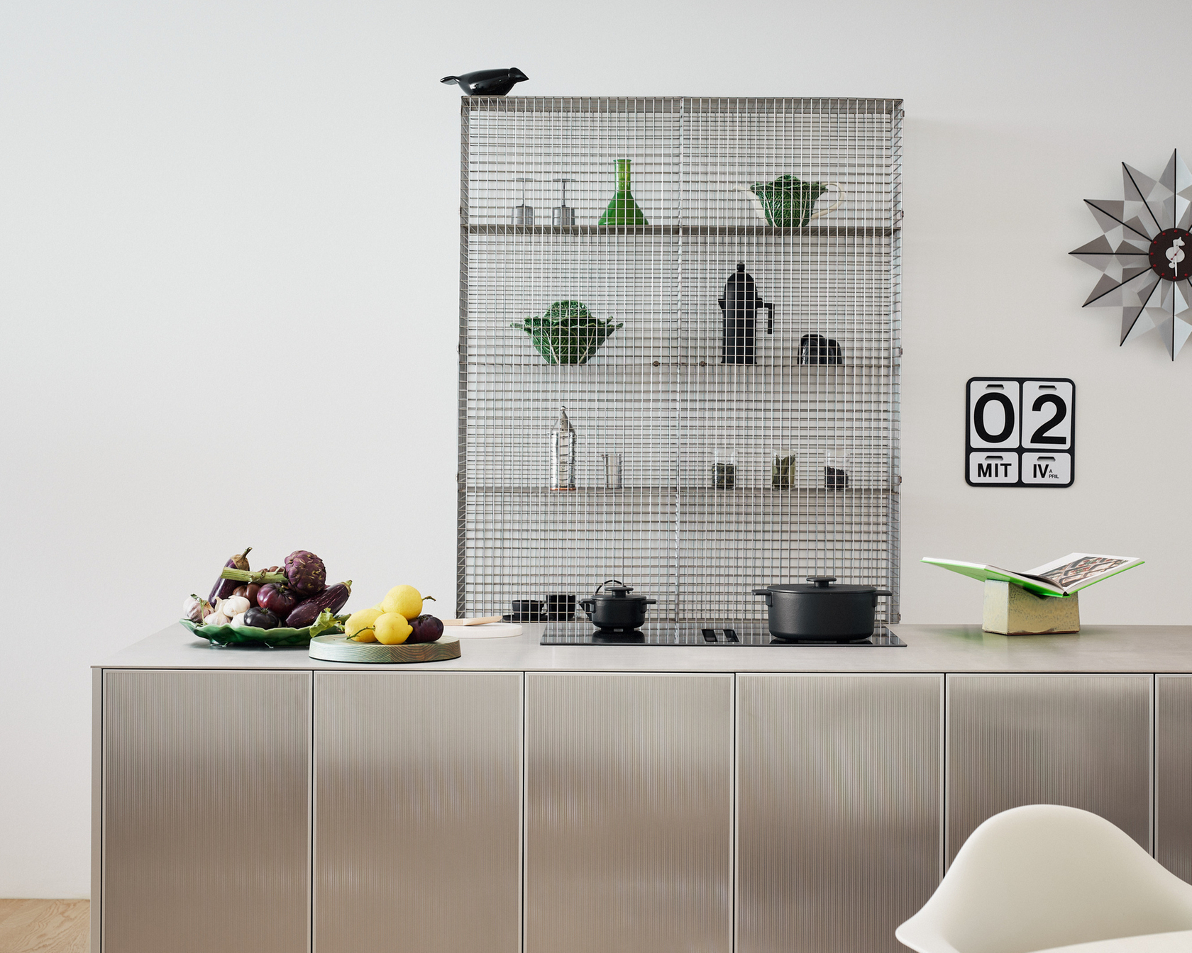 Modern kitchen with stainless steel cooking island and stylish accessories