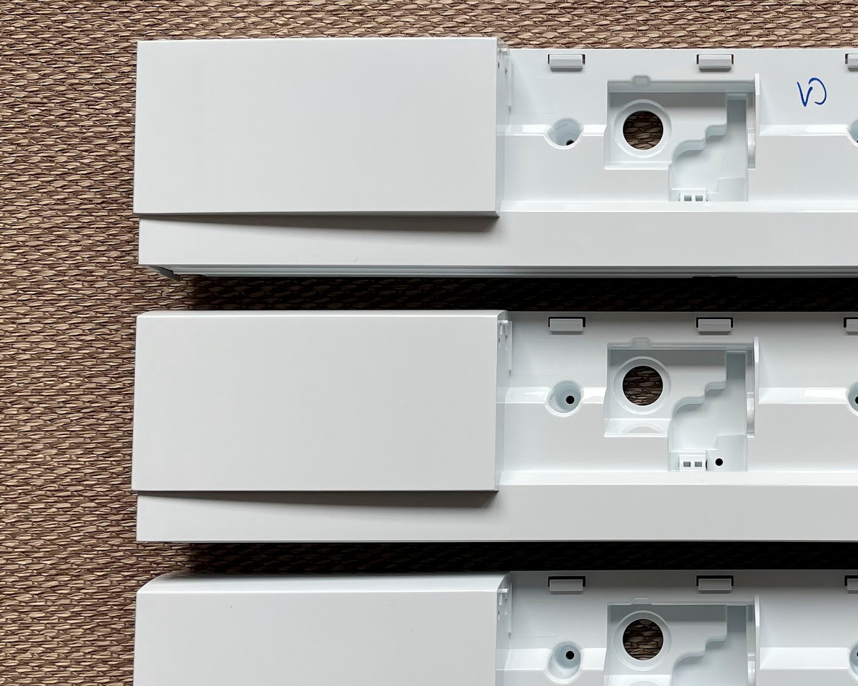 White plastic parts with cut-outs on a brown surface