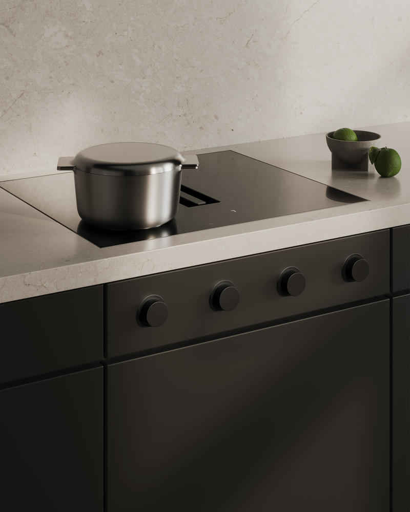 Table de cuisson moderne avec casserole en acier inoxydable et citrons verts sur un plan de travail de cuisine