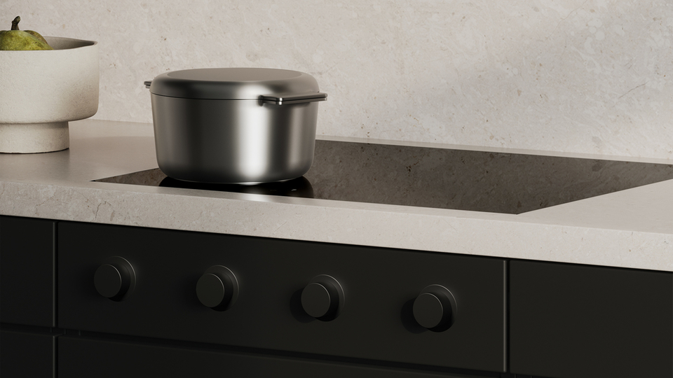 Piano cottura moderno con pentola in acciaio inox in una cucina minimalista