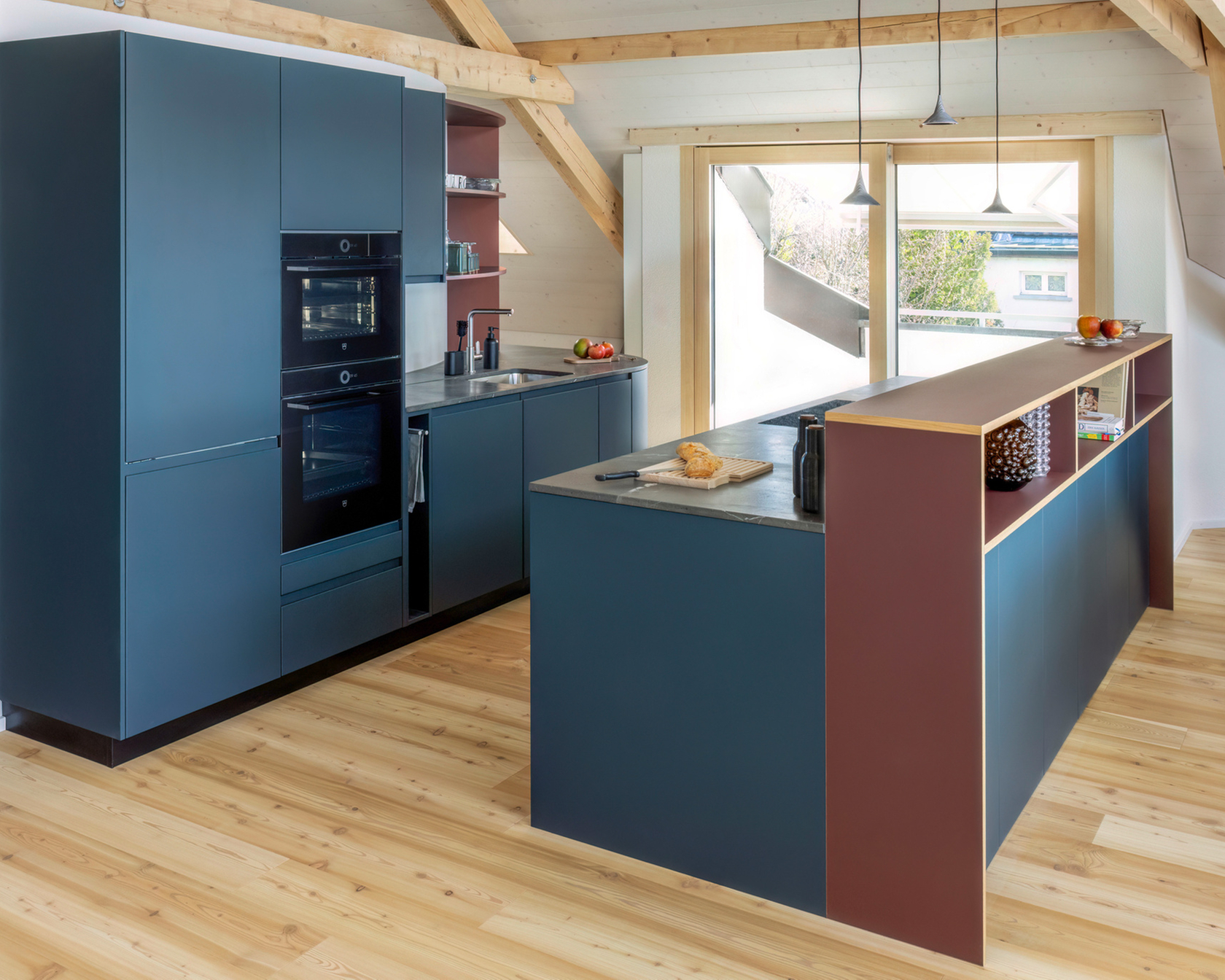 Modern kitchen with cooking island, built-in ovens and stylish design in a bright room.