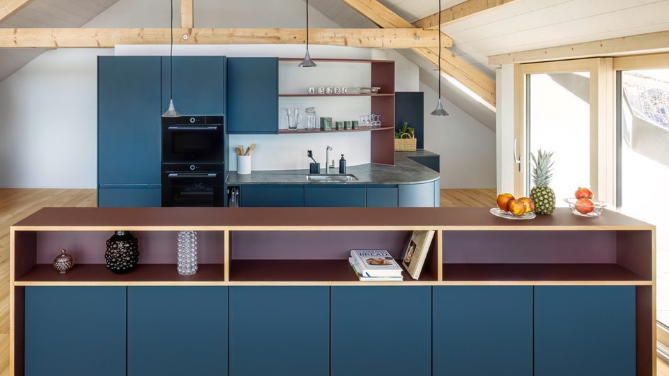 Modern kitchen with blue cabinets, wooden details and integrated appliances in an open space
