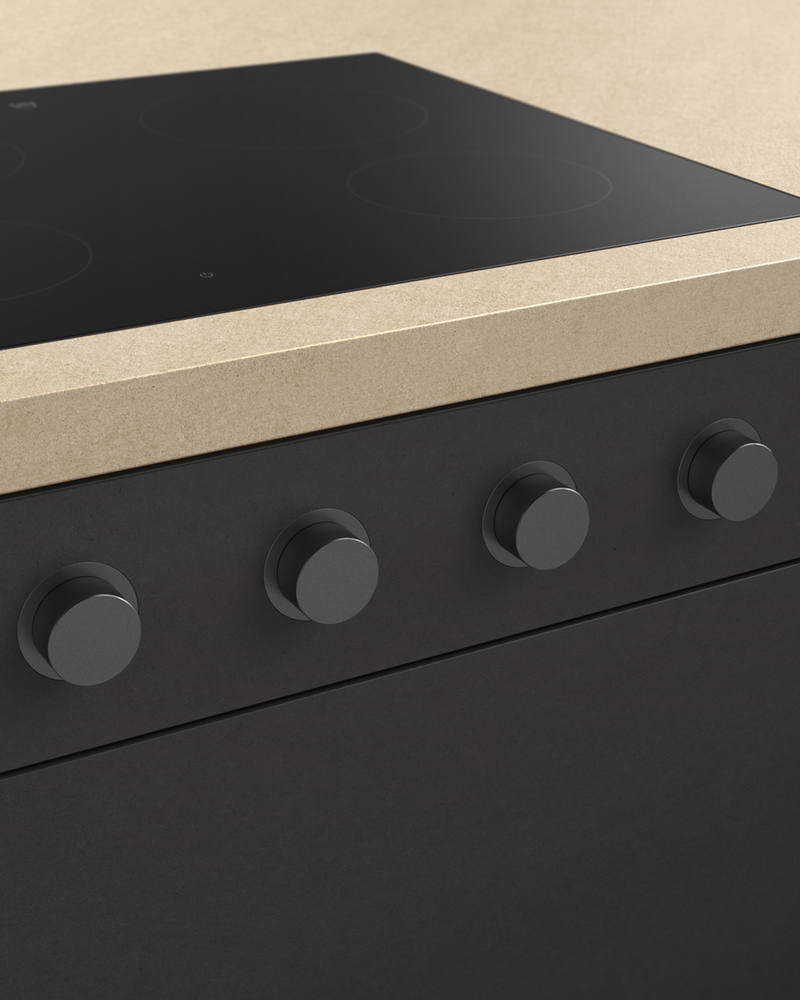 Piano cottura con manopole rotanti nere e piano di lavoro beige in una cucina moderna.