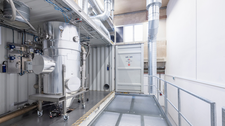 Interior view of an industrial plant with stainless steel components and piping.