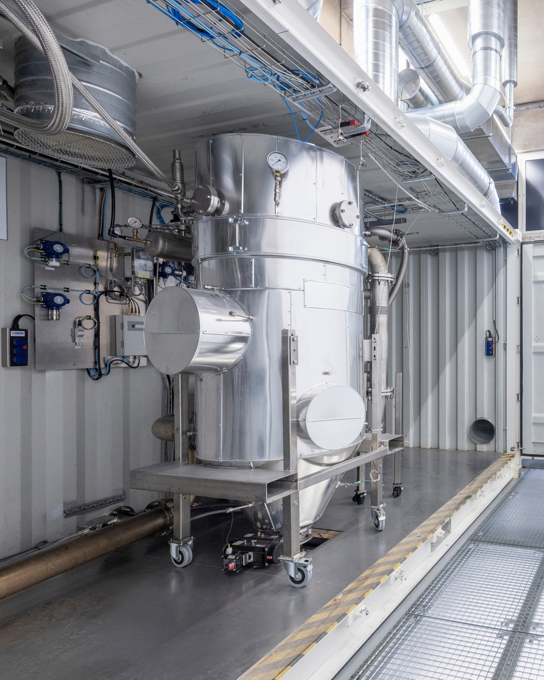 Interior view of an industrial plant with stainless steel components and piping.