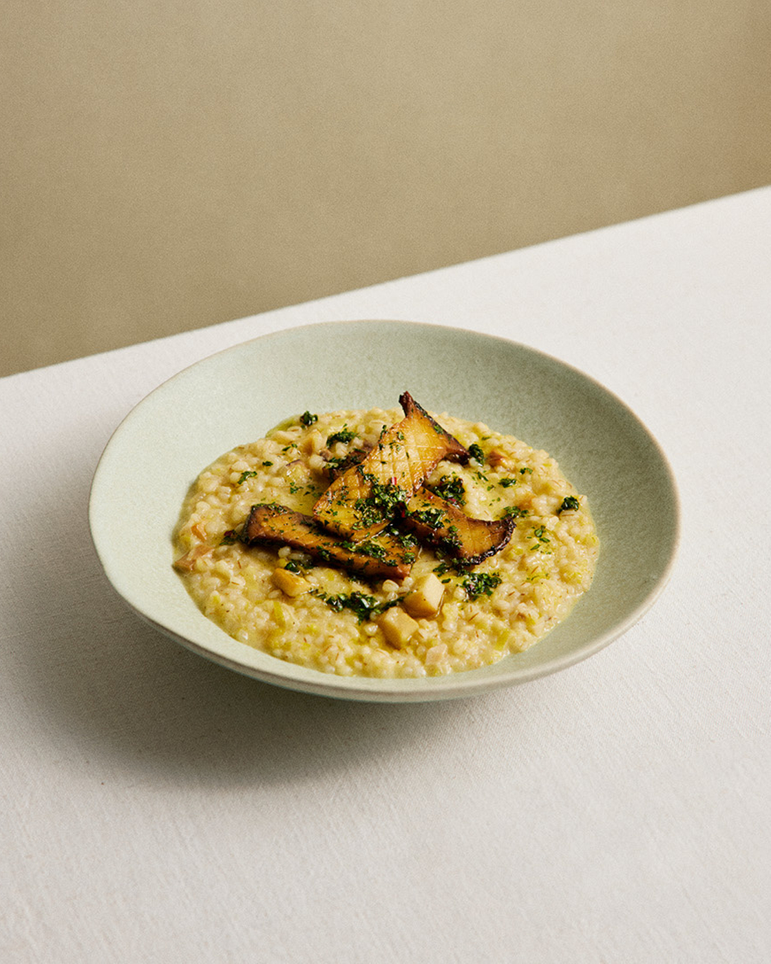 Risotto mit Pilzen und Kräutern auf einem Teller, perfekt angerichtet für eine köstliche Mahlzeit.