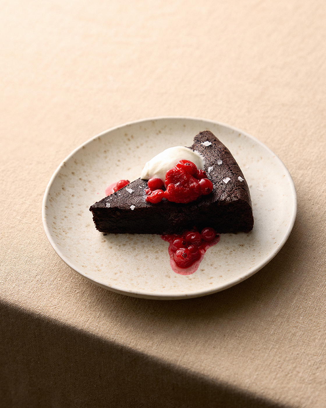 Chocolate cake with red berries and cream on a plate