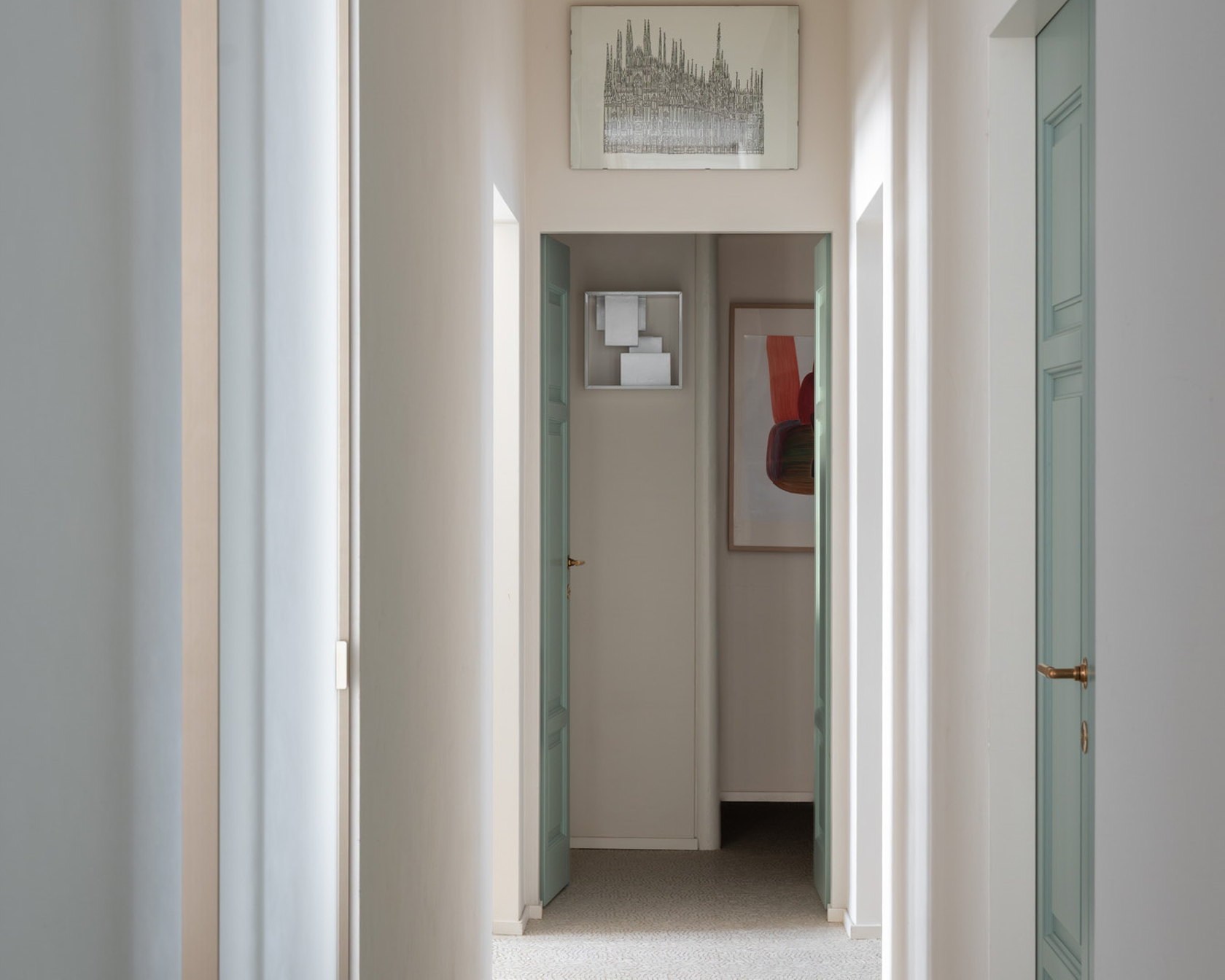 Bright hallway with artwork and pastel doors in a modern design