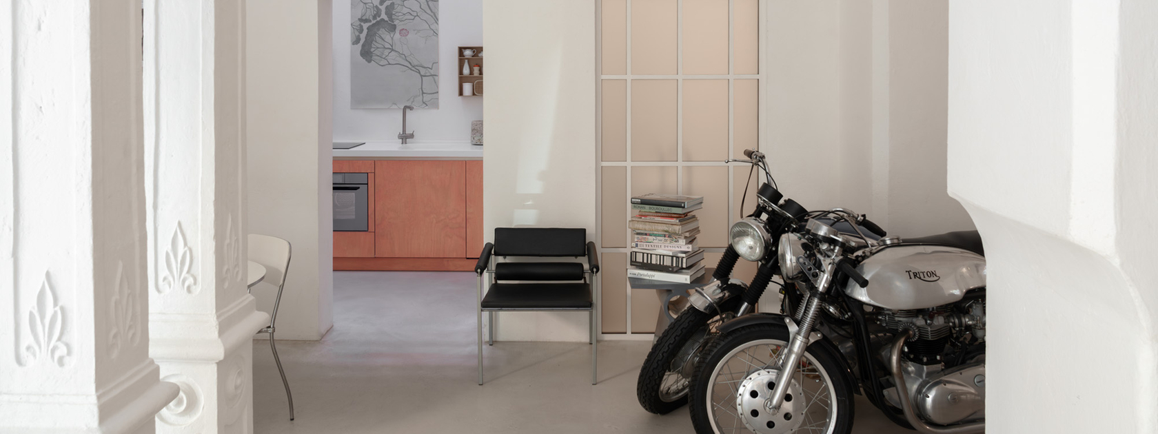 Motorcycle in front of a modern kitchen in a bright room with stylish details.