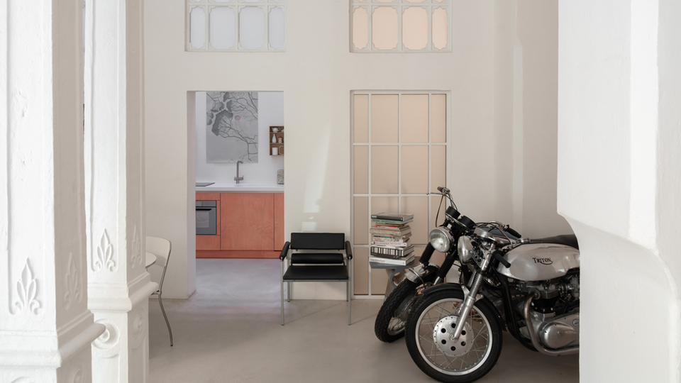 Motorcycle in front of a modern kitchen in a bright room with stylish details.