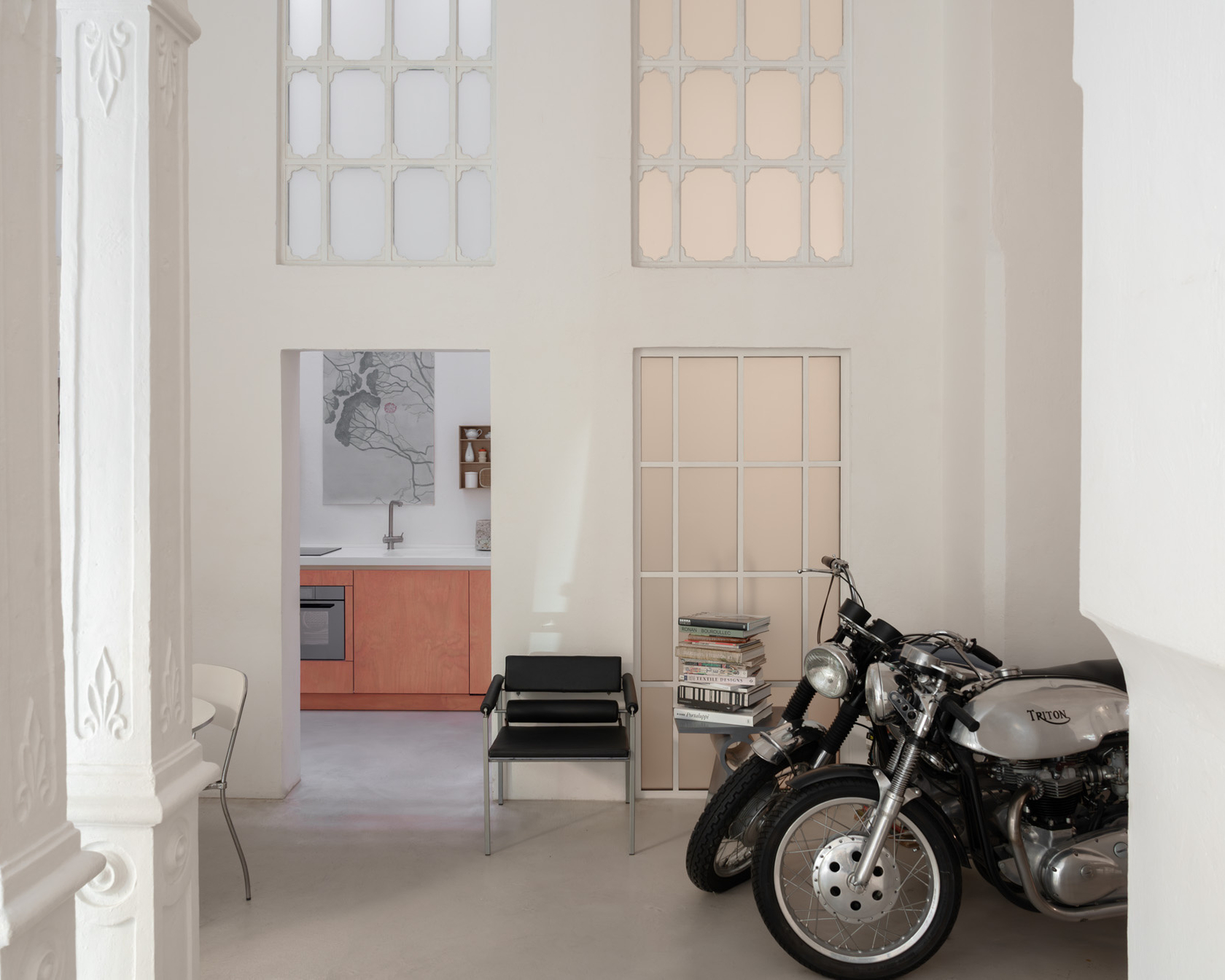Motorcycle in front of a modern kitchen in a bright room with stylish details.