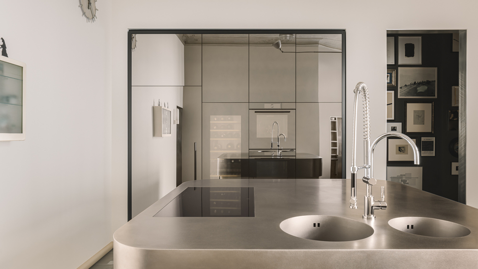 Modern kitchen with hob, sink and minimalist furnishings.