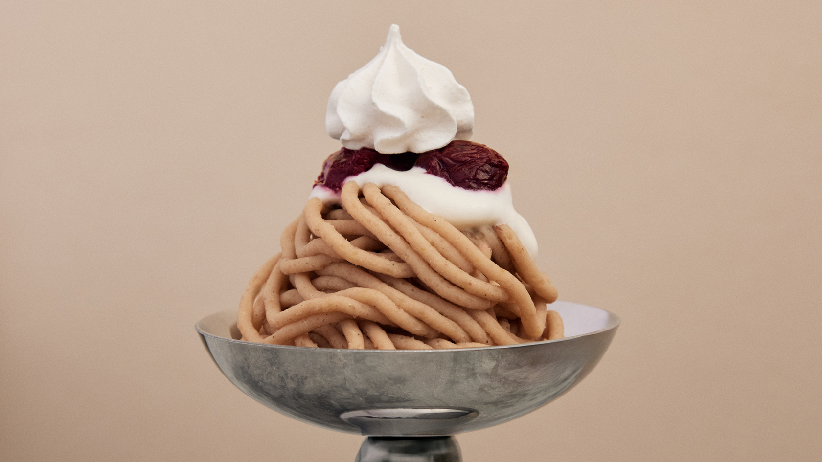 Dessert mit Sahne und Kirschen auf einem Metallteller