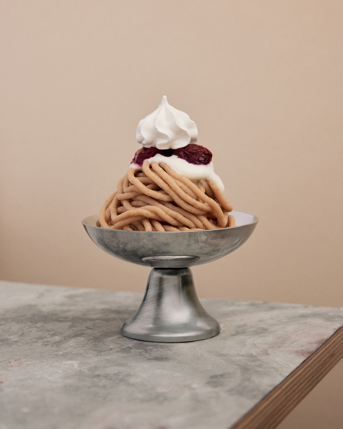 Dessert mit Sahne und Kirschen auf einem Metallteller