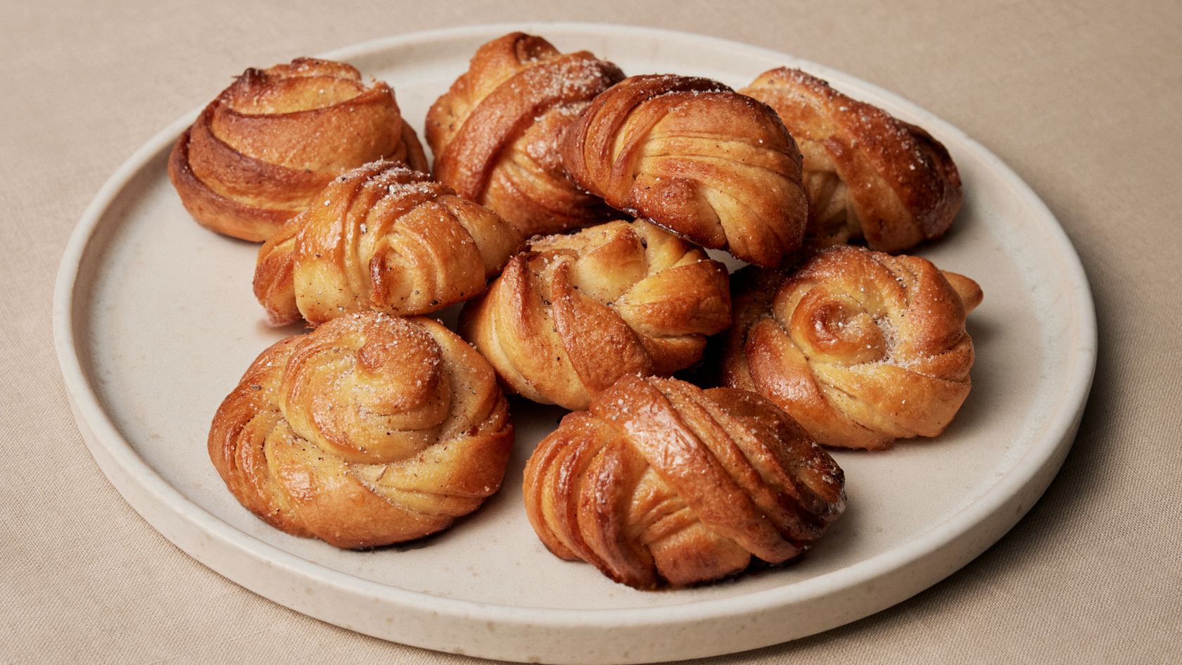 Freshly baked cinnamon buns on a ceramic plate, ideal for cozy moments.