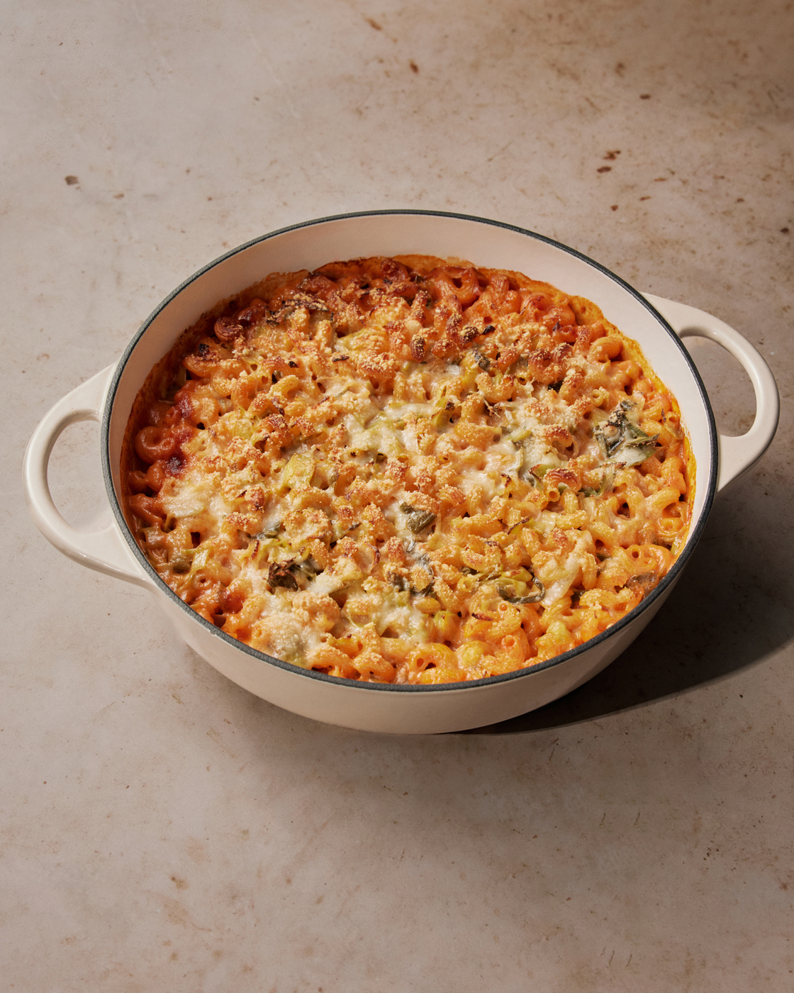 Freshly baked casserole in a white casserole dish on a light stone surface.