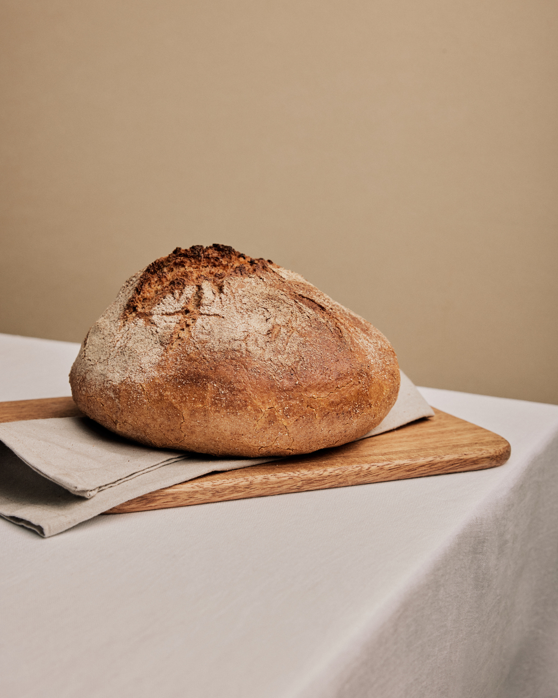Pain frais sur une planche en bois avec un torchon, représentation minimaliste