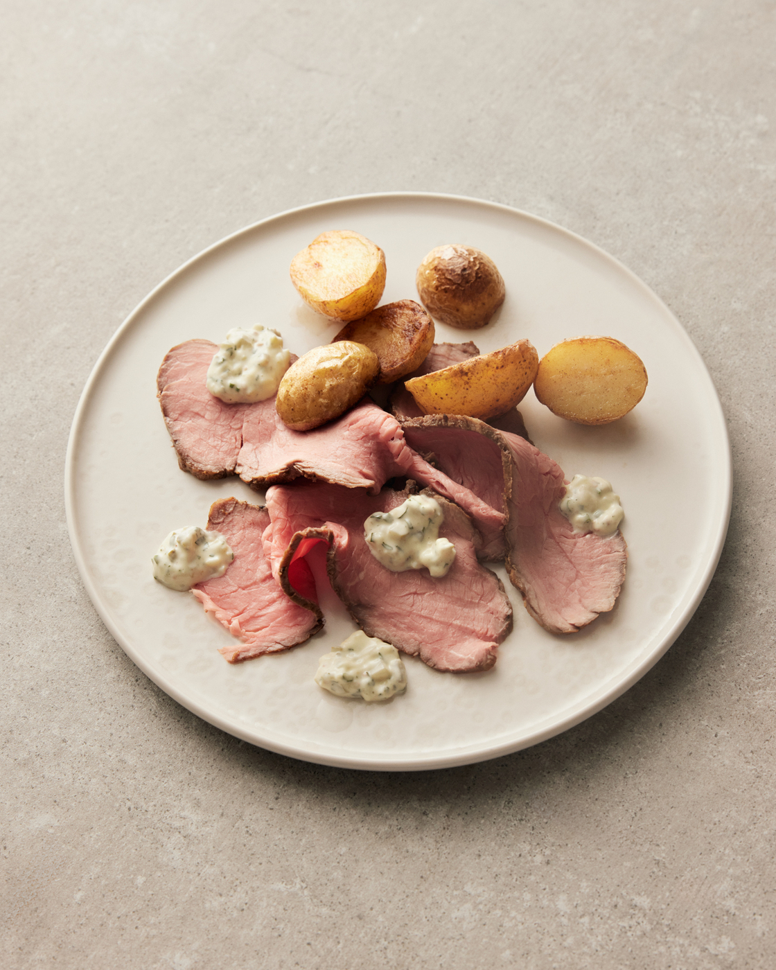 Fillet of beef with potatoes and creamy sauce on a plate