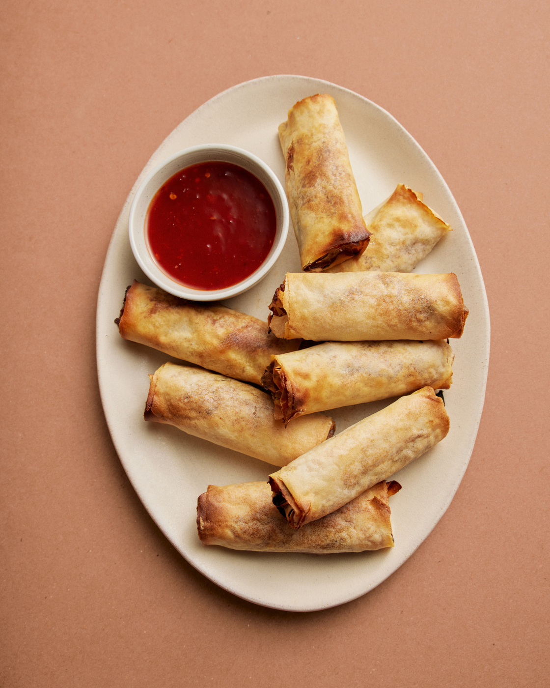 Involtini primavera su un piatto con salsa di immersione, perfetti per la cucina asiatica e gli spuntini.