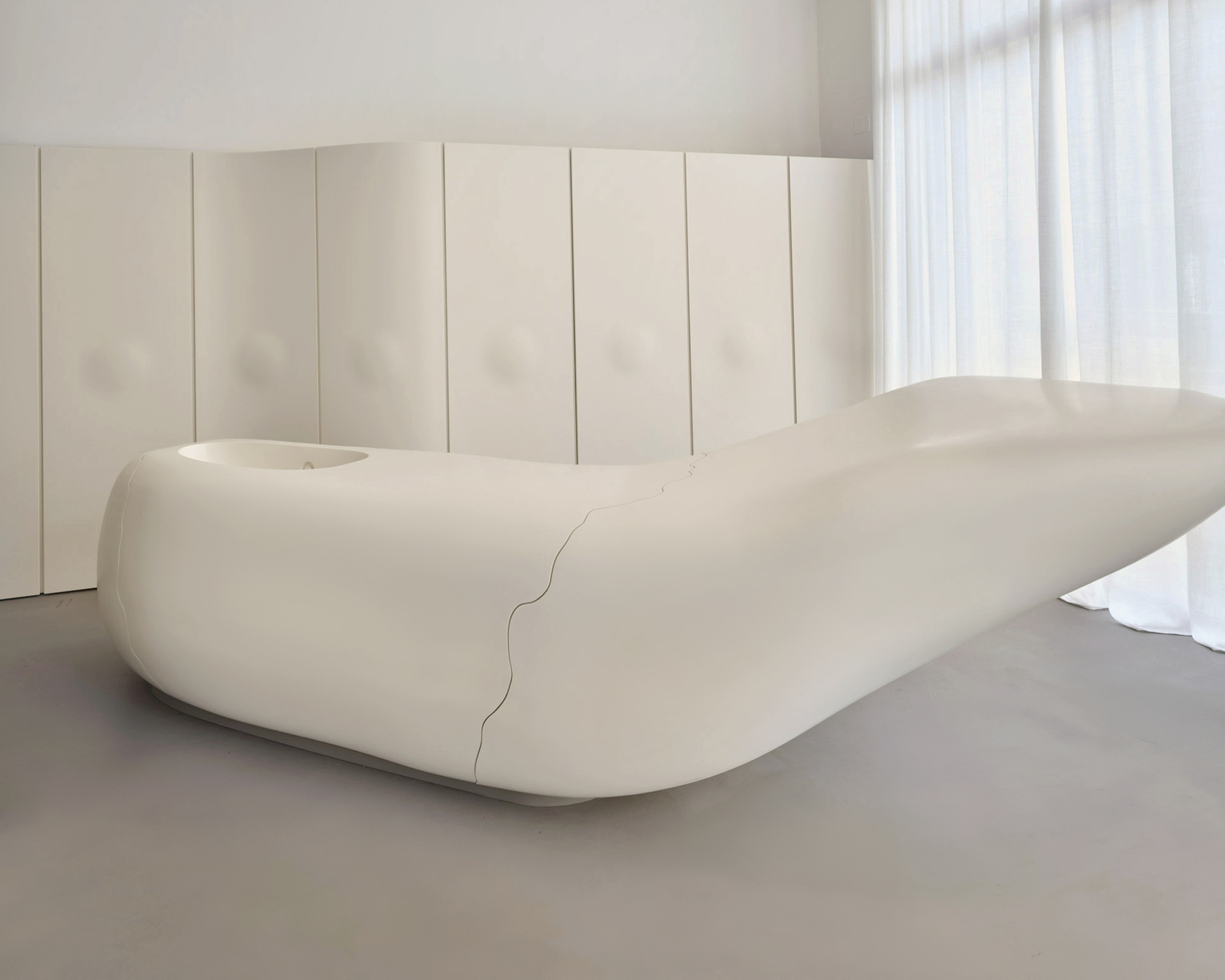 Minimalist design piece of furniture in a bright room with white curtains.