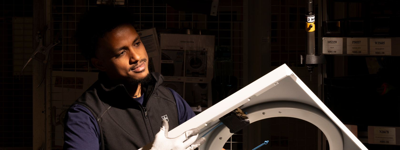 Installation of an extractor fan in a production facility with a worker in the background.