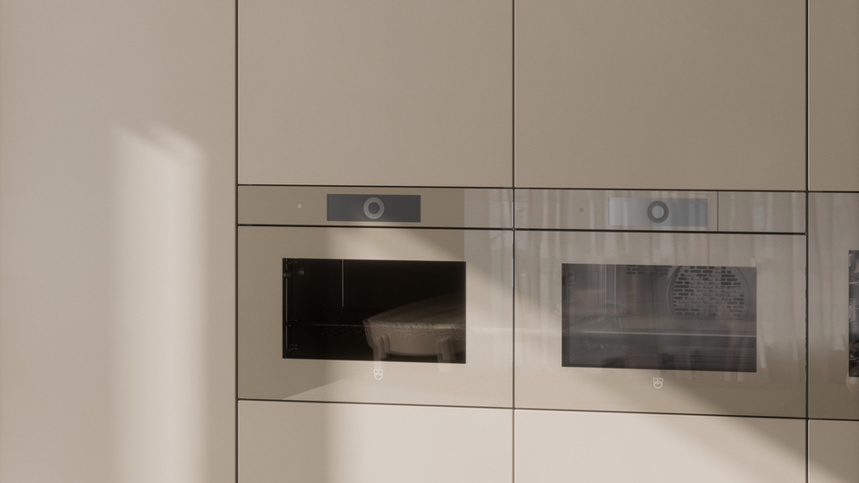 Minimalistisk køkken med indbyggede hvidevarer, en kogeplade og en tekande på en lys køkkenø