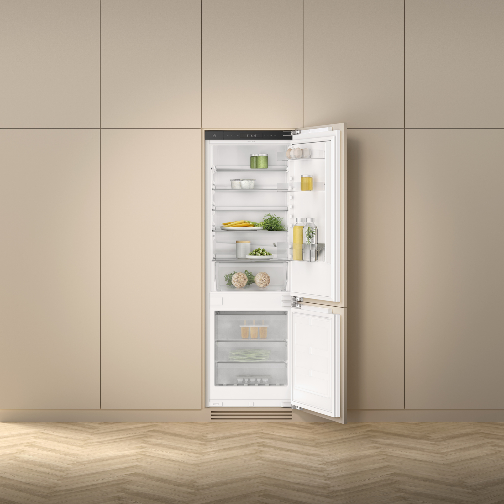 Réfrigérateur encastrable avec compartiment congélateur ouvert dans une cuisine minimaliste beige, contenant des produits frais