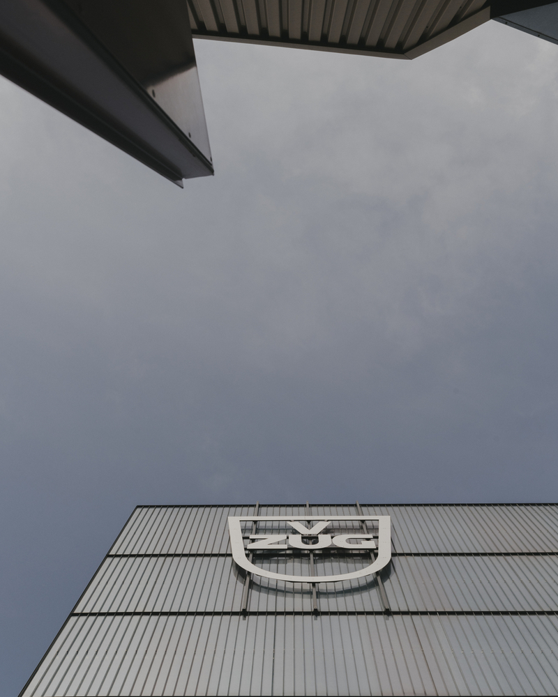 V-ZUG Gebäude mit Firmenlogo und moderner Architektur vor blauem Himmel